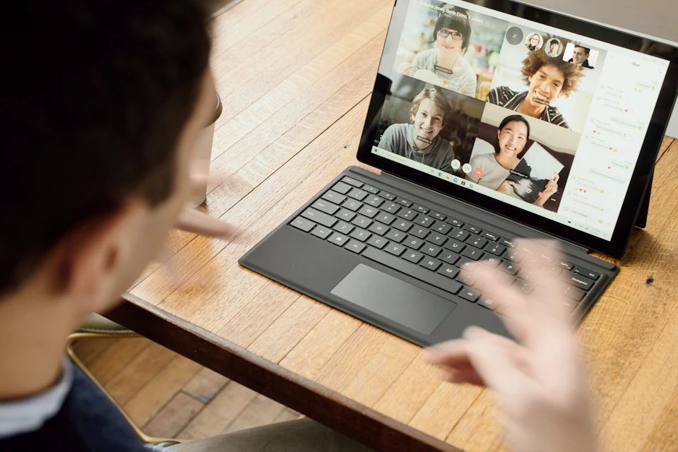 Portátil con una videollamada abierta sobre una mesa de trabajo